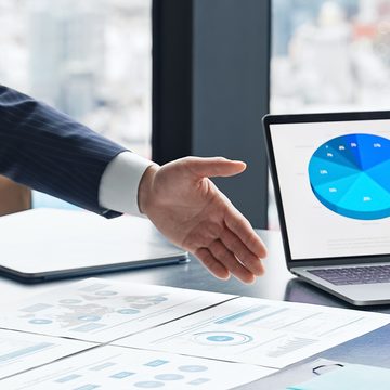 ノートPCのグラフを示しながら分析結果を説明するイメージ画像